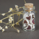 A glass jar of tiny ceramic hearts - each one cut out and glazed by hand with a deep red glaze