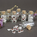 A glass jar of tiny ceramic hearts - each one cut out and glazed by hand with a deep red glaze